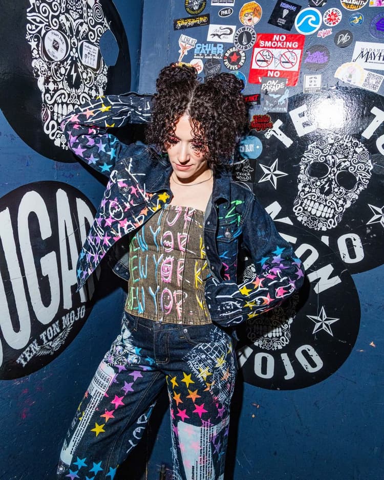 Ali against the sticker wall at Arlene’s Grocery