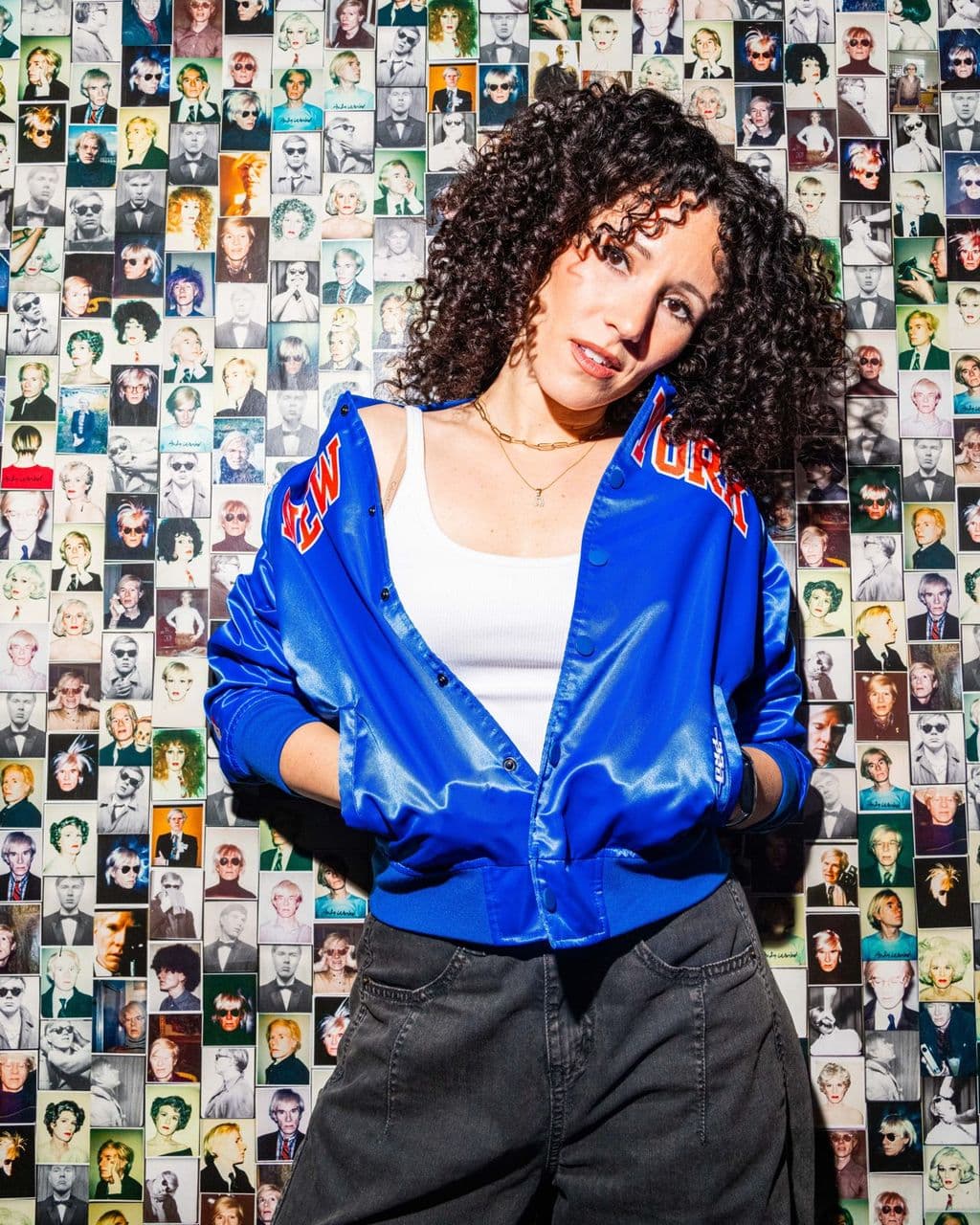 Press photo: Ali against a photo-collage wall