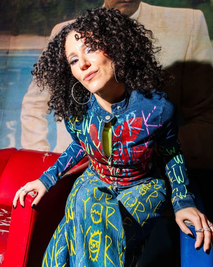 Press photo: Ali in the graffiti jacket on a red couch