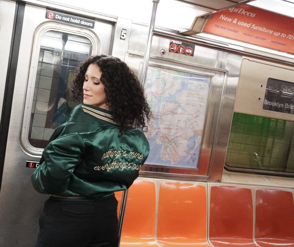 Press photo: Ali in a green satin jacket on the subway