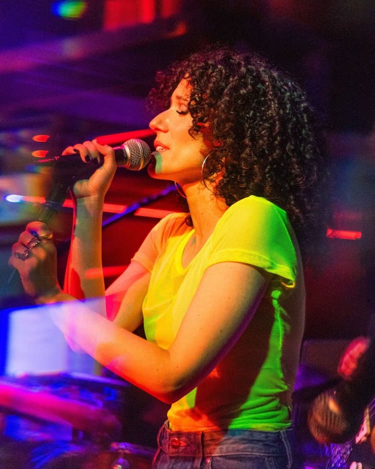 Ali in a neon top singing at Nublu